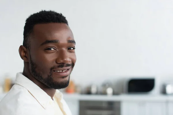 Fröhlicher afrikanisch-amerikanischer Mann lächelt und blickt in die Kamera — Stockfoto
