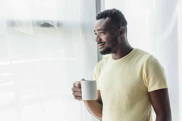 Gai homme afro-américain tenant tasse avec du thé — Photo de stock