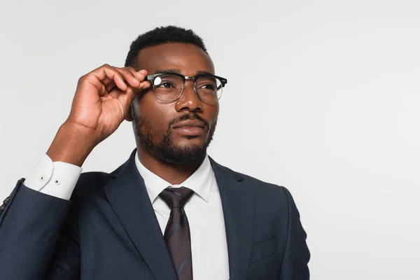 African american man adjusting eyeglasses isolated on grey — Stock Photo