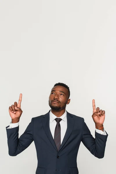 Uomo d'affari afroamericano in giacca e cravatta che punta con le dita isolate sul grigio — Foto stock