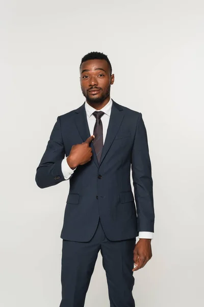 African american businessman in suit pointing with finger at himself isolated on grey — Stock Photo