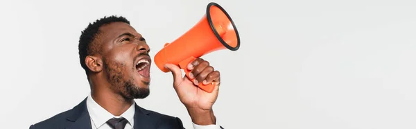 Homme d'affaires afro-américain en costume criant dans mégaphone isolé sur gris, bannière — Photo de stock