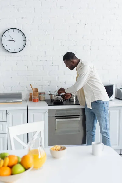 Barbudo afro-americano homem segurando panela de café na cozinha — Fotografia de Stock