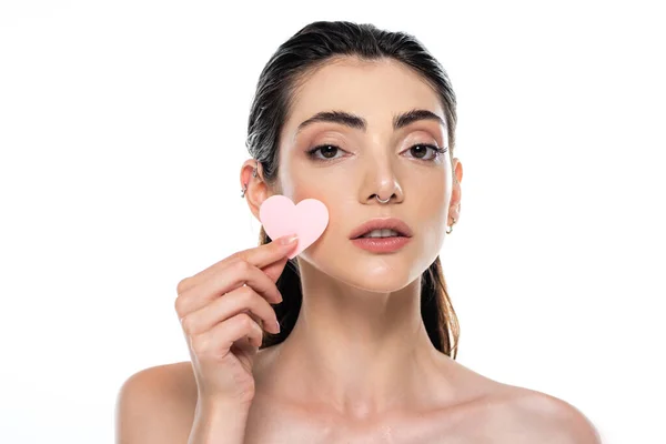 Pierced young woman with bare shoulders holding heart-shape sponge isolated on white — Stock Photo