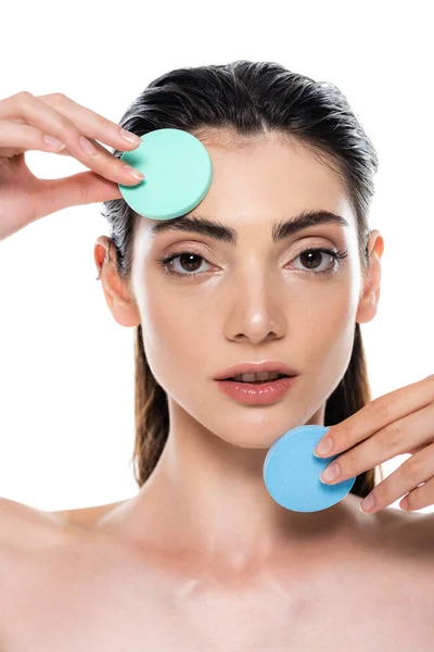 Mujer joven sosteniendo esponjas azules de belleza aisladas en blanco - foto de stock