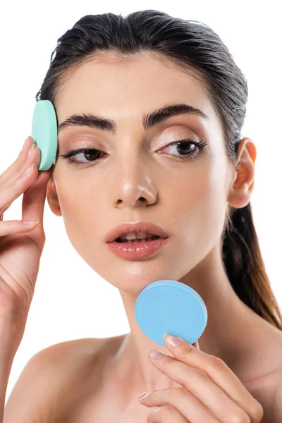 Pretty woman holding blue beauty sponges isolated on white — Stock Photo