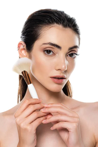 Young brunette woman holding cosmetic brush isolated on white — Stock Photo