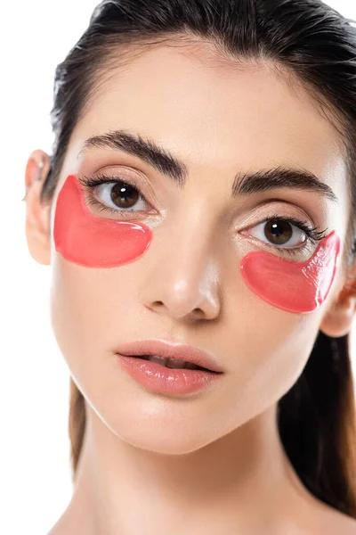 Primer plano de la mujer joven y bonita con parches en los ojos aislados en blanco - foto de stock