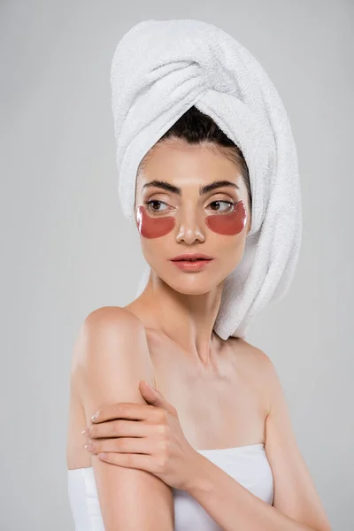 Pretty young woman with bare shoulders and eye patches isolated on grey — Stock Photo