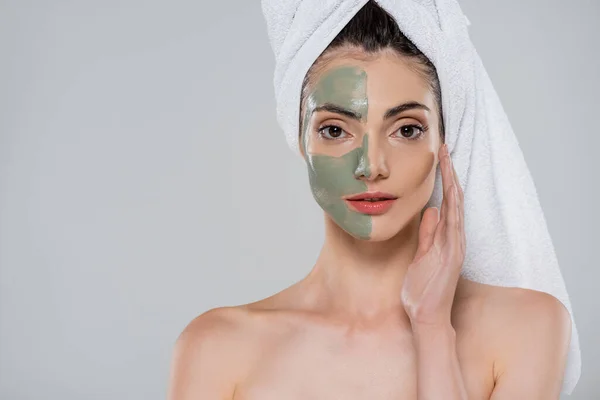 Молода жінка з голими плечима і зелену глиняну маску на обличчі ізольовано на сірому — стокове фото