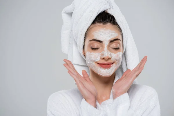 Mujer joven satisfecha con exfoliante facial aislado en gris - foto de stock