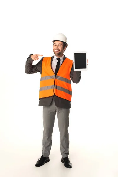 Ingeniero sonriente apuntando a la tableta digital sobre fondo blanco - foto de stock