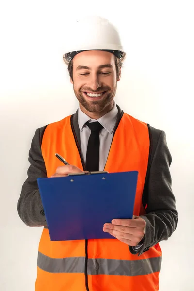 Engenheiro sorridente escrevendo na área de transferência em fundo branco — Fotografia de Stock