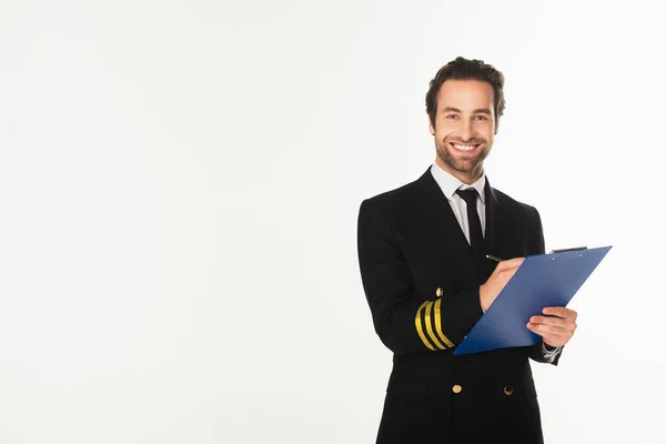 Smiling pilot writing on clipboard isolated on white — Stock Photo