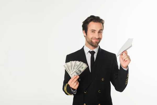 Pilota sorridente in possesso di aereo di carta e dollari isolati su bianco — Foto stock