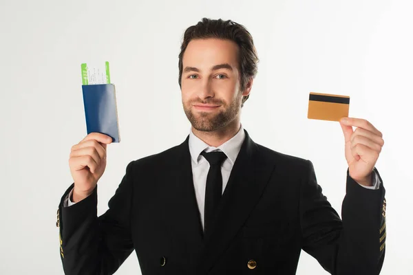 Pilot holding passport with air ticket and credit card isolated on white — Stock Photo