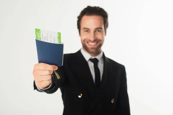 Pasaporte con billete de avión en mano de aviador borroso aislado en blanco - foto de stock