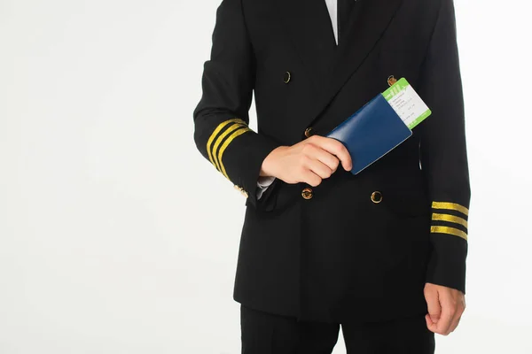 Vista recortada del aviador en traje con pasaporte y tarjeta de embarque aislado en blanco - foto de stock
