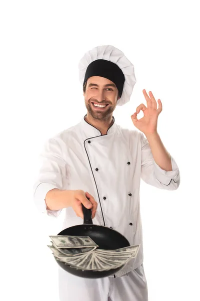 Chef mostrando gesto ok e segurando frigideira com dólares isolados em branco — Fotografia de Stock