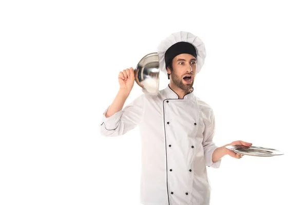 Amazed chef holding cloche near ear isolated on white — Stock Photo