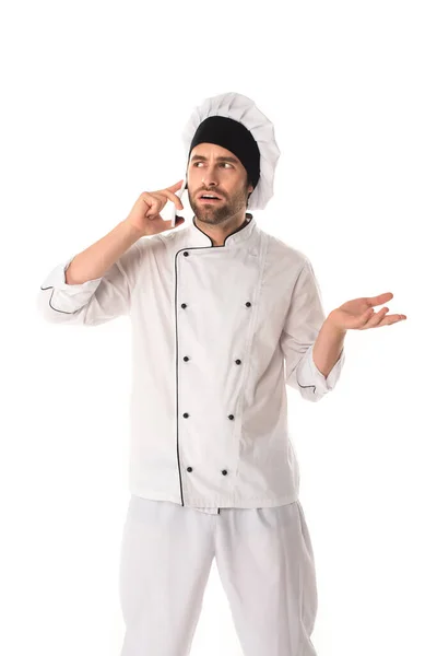 Confused chef talking on smartphone isolated on white — Stock Photo