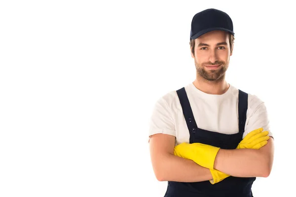 Limpiador en uniforme y guantes de goma de pie con brazos cruzados aislados en blanco - foto de stock