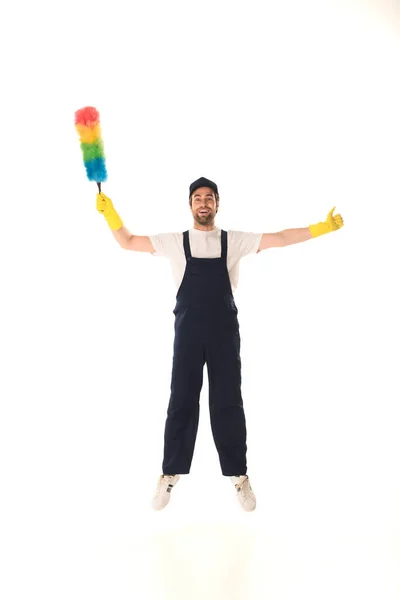 Excited cleaner with dust brush showing like while jumping isolated on white — Stock Photo