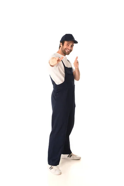 Pleine longueur de nettoyant souriant pointant vers la caméra sur fond blanc — Photo de stock