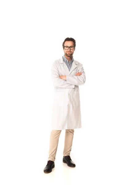 Full length of doctor standing with crossed arms on white background — Stock Photo