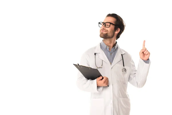 Médico sorridente com prancheta tendo ideia isolada em branco — Fotografia de Stock