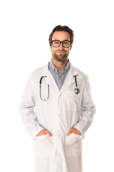 Médico en gafas con las manos en bolsillos aislados en blanco - foto de stock