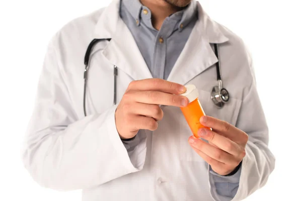 Cropped view of blurred doctor holding jar with pills isolated on white — Stock Photo