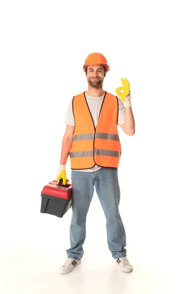 Smiling repairman holding toolbox and showing ok on white background — Stock Photo