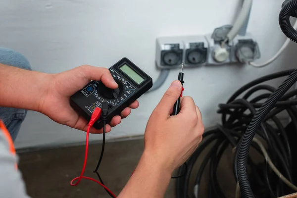 Vue recadrée de l'ouvrier tenant testeur électrique — Photo de stock