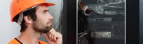 Side view of pensive repairman looking at switchboard, banner — Stock Photo