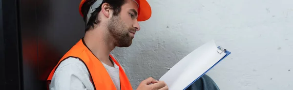 Side view of serviceman looking at clipboard, banner — Stock Photo