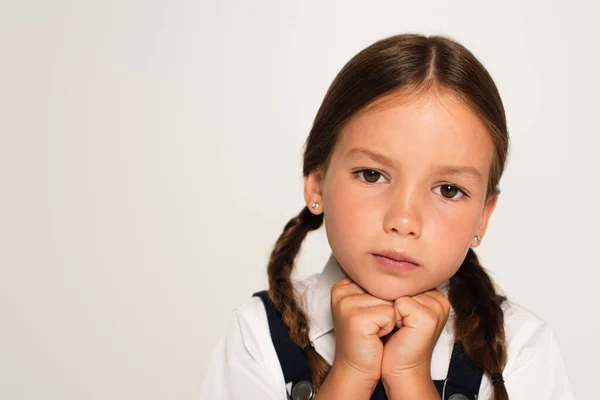 Retrato de colegial pensativo con las manos cerca de la barbilla aislado en gris - foto de stock