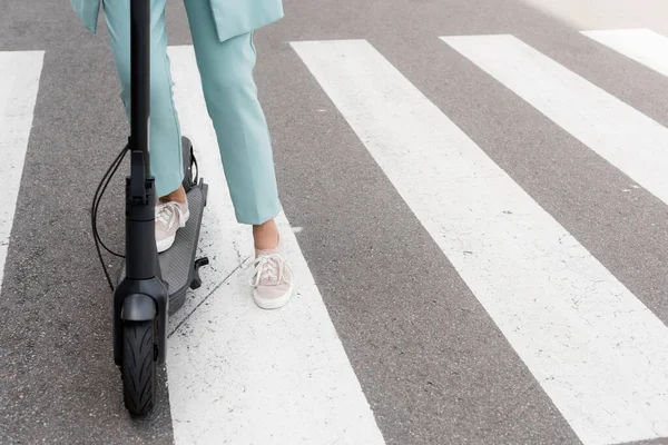 Vue recadrée de femme d'affaires debout sur scooter de coup de pied électrique — Photo de stock