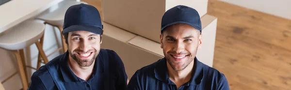 Happy handymen in caps looking at camera, banner — Stock Photo