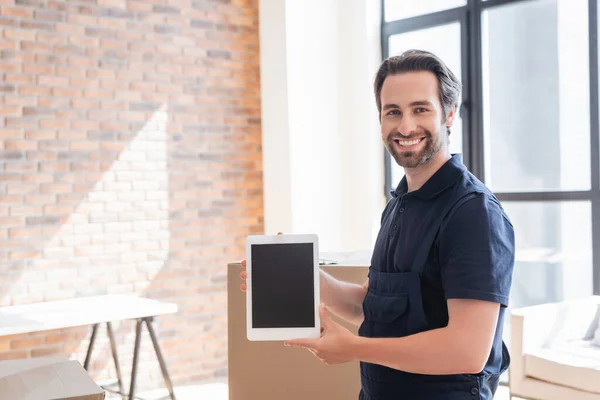 Glücklicher Vorarbeiter zeigt digitales Tablet mit leerem Bildschirm, während er in die Kamera schaut — Stockfoto