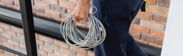 Partial view of repairmen with wires in apartment, banner — Stock Photo