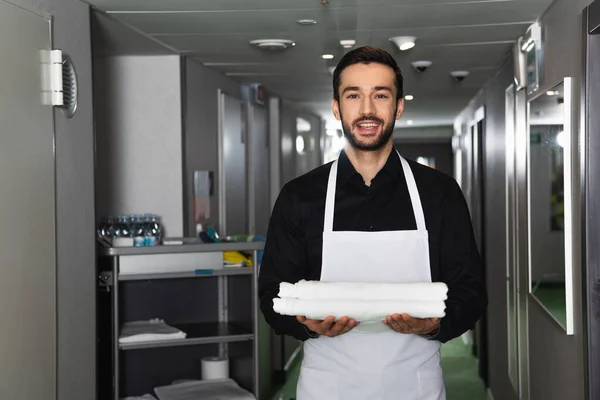 Улыбающаяся и бородатая домработница с белыми простынями — Stock Photo