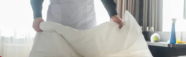 Обрезанный вид уборщицы смена постельного белья в номере отеля, баннер — стоковое фото