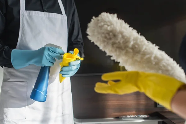 Cropped view of housekeepers with cleaning supplies — Stock Photo