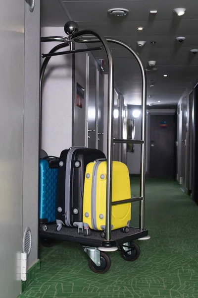 Modern luggage on metallic bell cart in hotel hall — Stock Photo