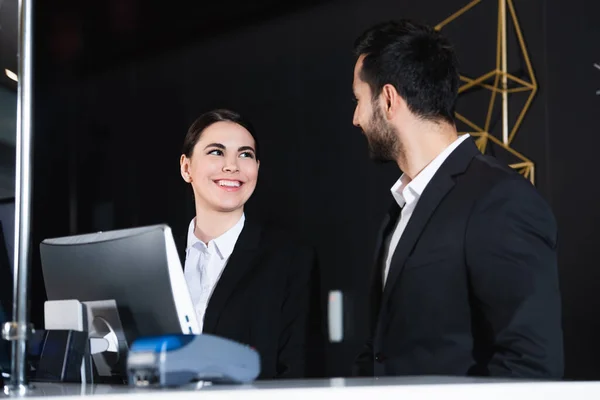 Happy administrators looking at each other in front desk — Stock Photo