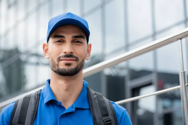 Mensajero árabe con mochila mirando a la cámara al aire libre - foto de stock