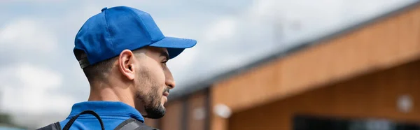 Side view of muslim courier with backpack looking away outdoors, banner — Stock Photo