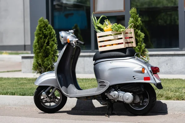 Box with vegetables on scooter outdoors — Stock Photo