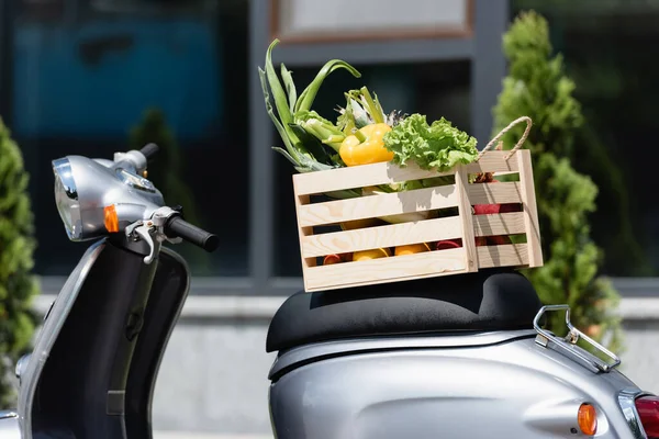 Wooden box with fresh vegetables on scooter outdoors — Stock Photo